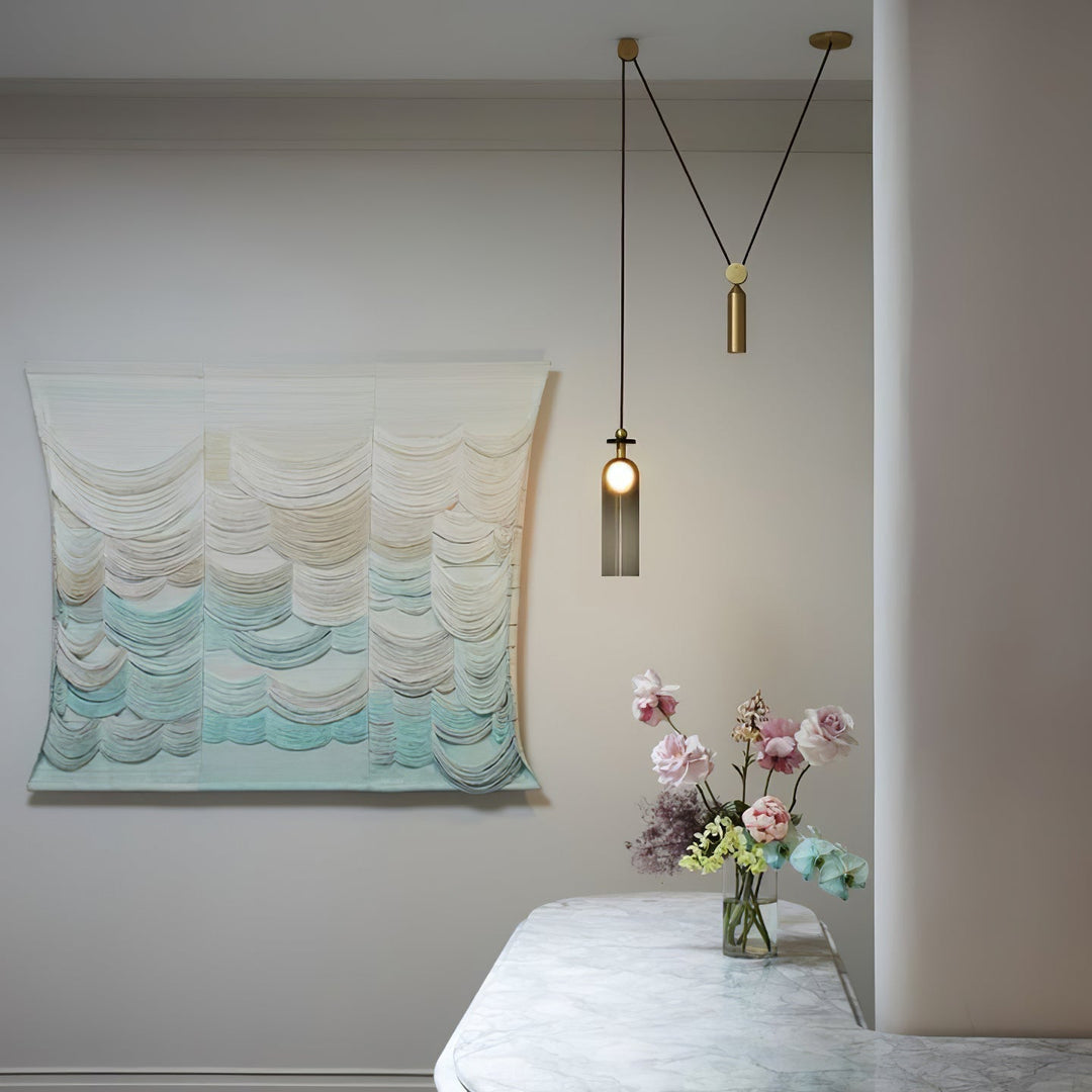 Room interior with wall art, pendant light, and floral arrangement.  Artelux Atelier